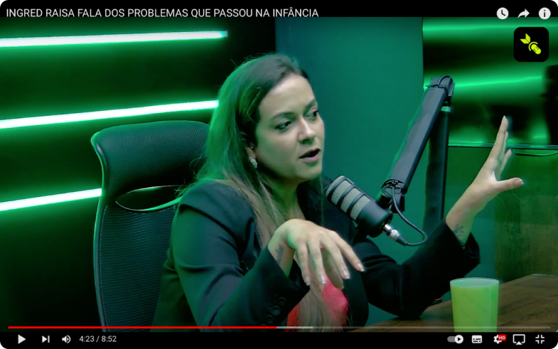 Une femme parle dans un microphone dans un studio éclairé en vert.